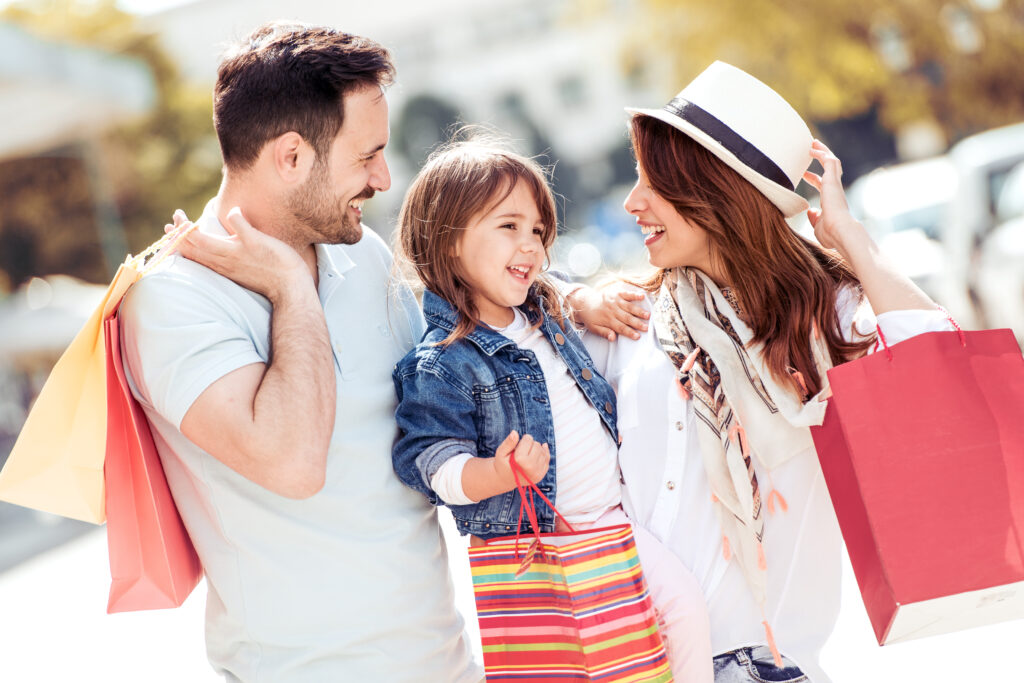 Happy family with little child and shopping bags.