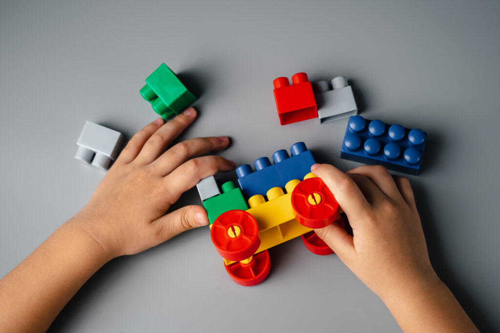 Small hands holding colorful lego toys