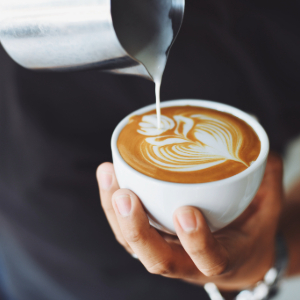 Pouring cream in a cup of espresso