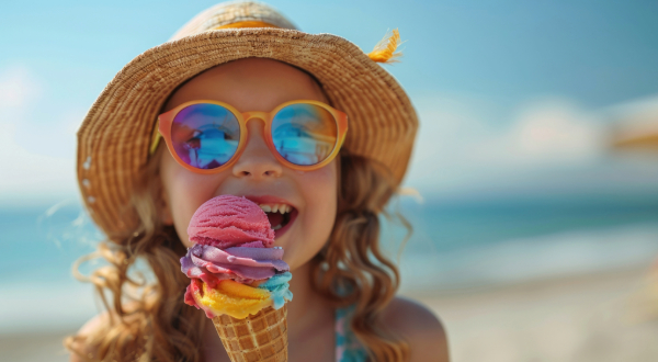 young girl eating ice cream on the beach